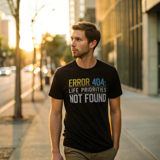 Male model walking an urban sidewalk in a black crew-neck t-shirt with “Priorities Not Found” tech graphic, lifestyle street shot at golden hour.