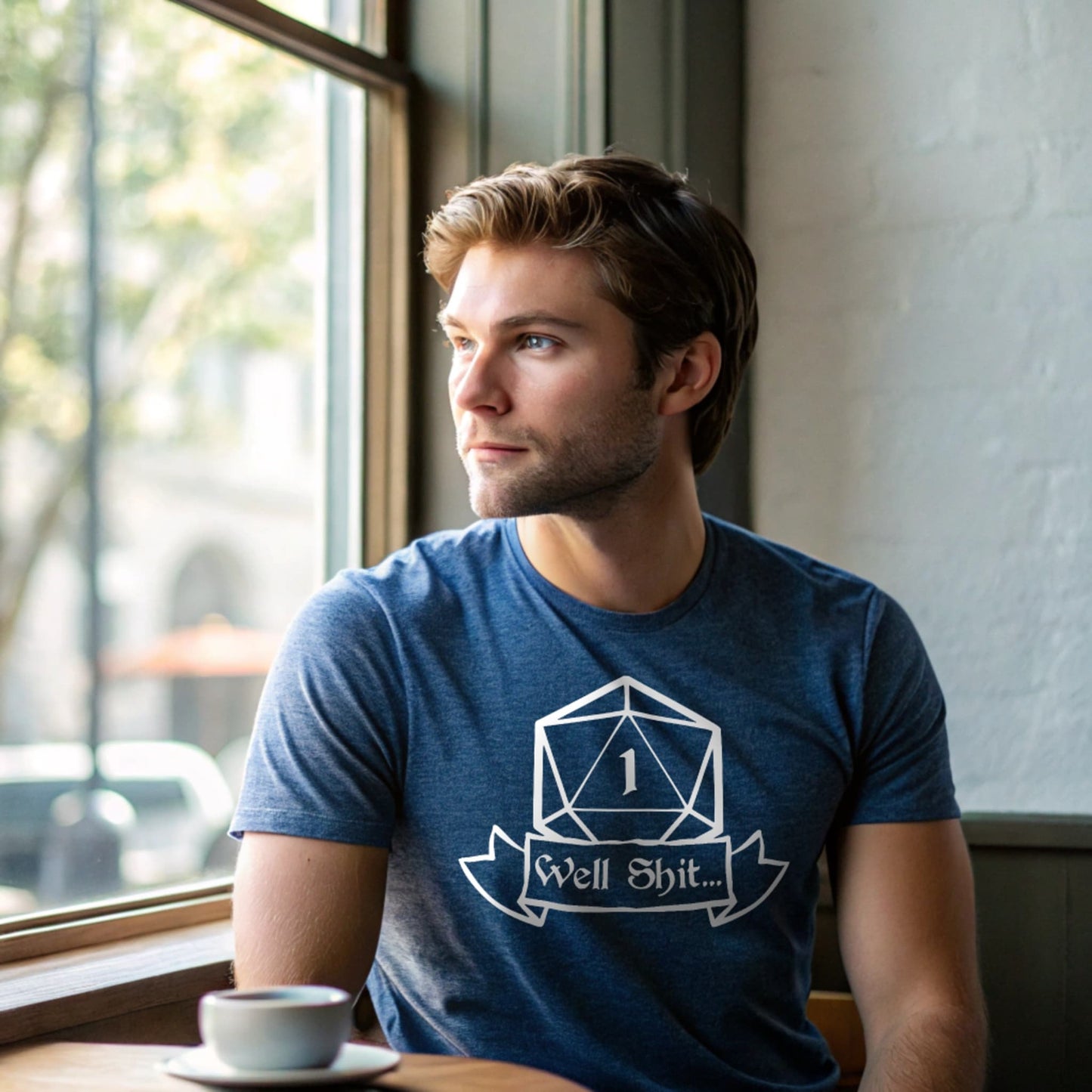 Man sitting in cafe wearing heather indigo Critical Fail T-shirt, lifestyle mockup