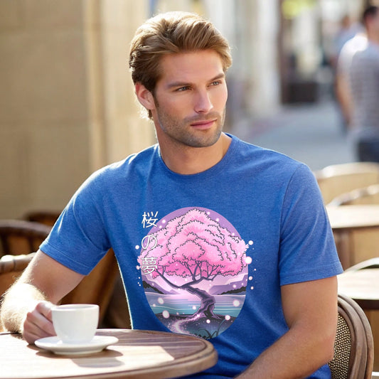 Male model leaning on a fence in a heather royal crew-neck t-shirt with pink cherry-tree graphic, lifestyle outdoor shot.