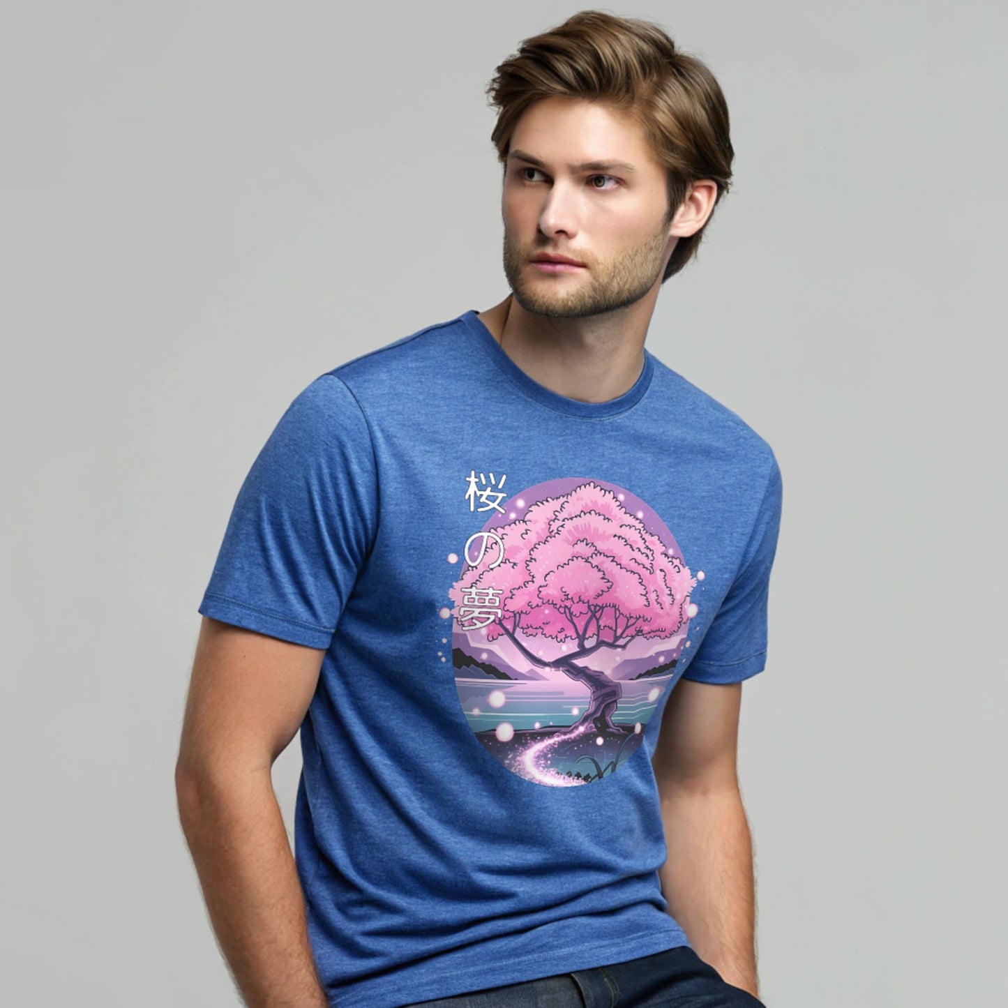 Male model wearing a heather royal crew-neck t-shirt with pink cherry-tree graphic, studio shot by a window-lit backdrop.