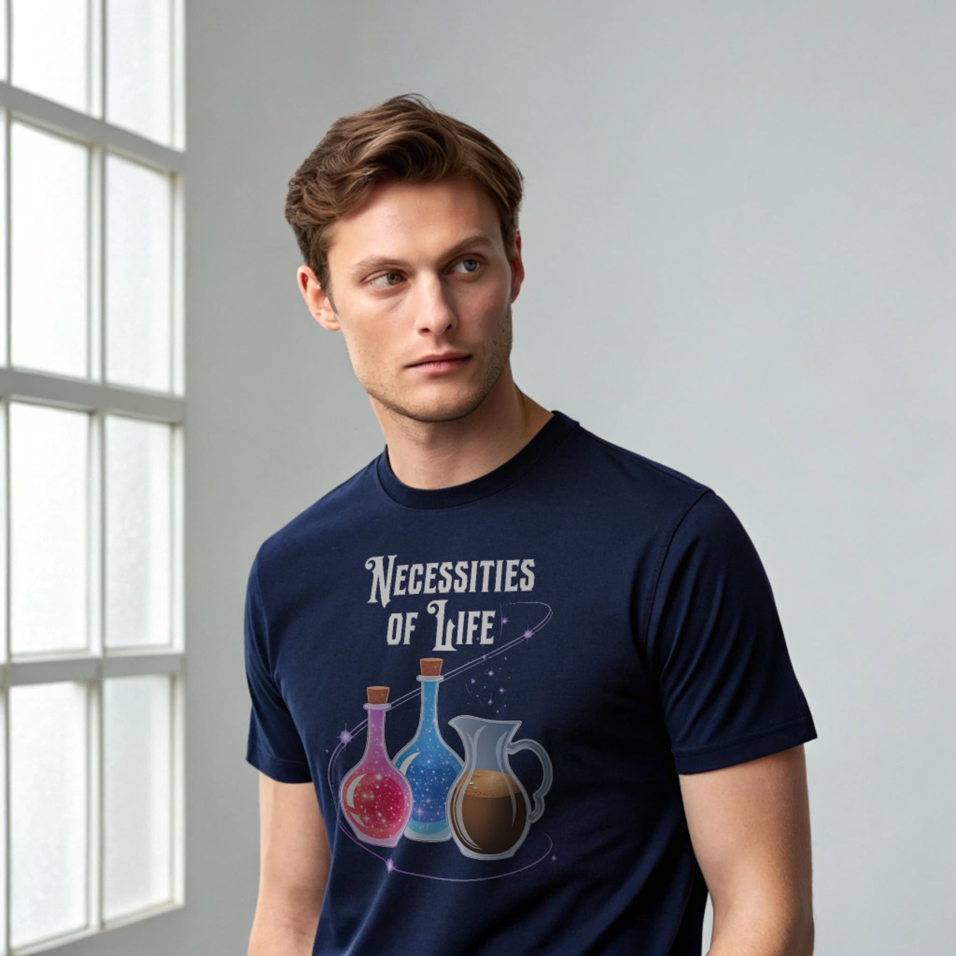 Male model wearing a navy crew-neck t-shirt with “Necessities of Life” potion graphic, studio shot against a gray wall.