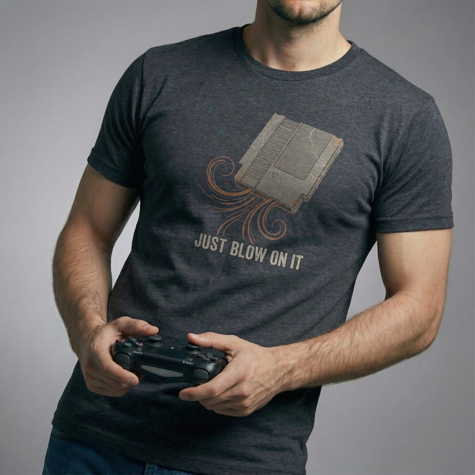 The Universal Fix Retro Gaming T-Shirt in Dark Circuit color. Man holding controller, showing vintage 8-bit cartridge graphic. High-quality Bella Canvas 3001.