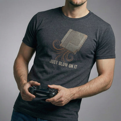 The Universal Fix Retro Gaming T-Shirt in Dark Circuit color. Man holding controller, showing vintage 8-bit cartridge graphic. High-quality Bella Canvas 3001.