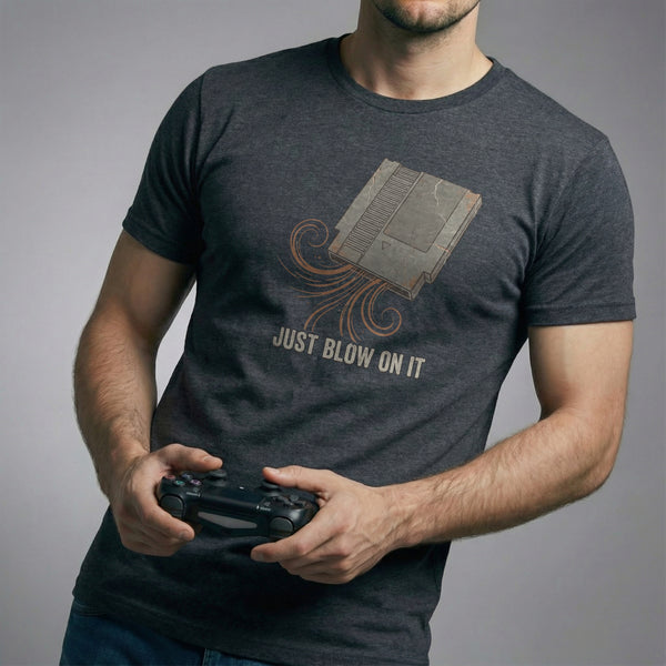 The Universal Fix Retro Gaming T-Shirt in Dark Circuit color. Man holding controller, showing vintage 8-bit cartridge graphic. High-quality Bella Canvas 3001.