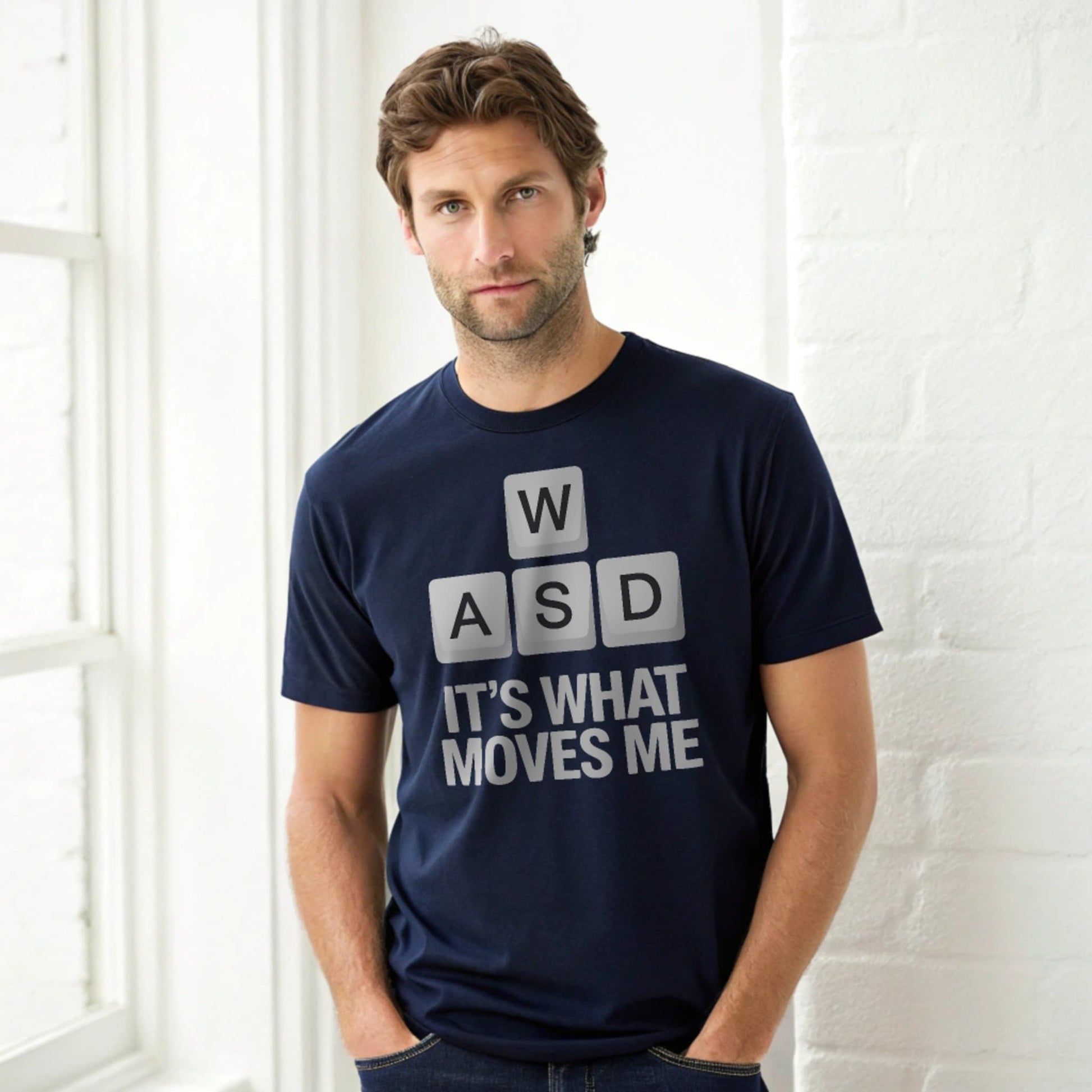 Hyper-realistic mockup of a 25–40-year-old man wearing a plain Gildan 64000 navy crew-neck t-shirt with the WASD Moves design, leaning against a white brick wall.