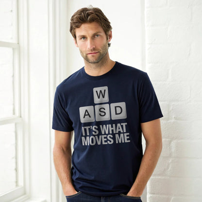 Hyper-realistic mockup of a 25–40-year-old man wearing a plain Gildan 64000 navy crew-neck t-shirt with the WASD Moves design, leaning against a white brick wall.
