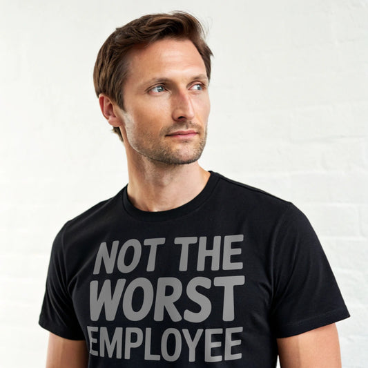 Hyper-realistic mockup of a 25–40-year-old man wearing a plain Gildan 64000 crew-neck black t-shirt (no graphics) standing face-on against a white brick wall.